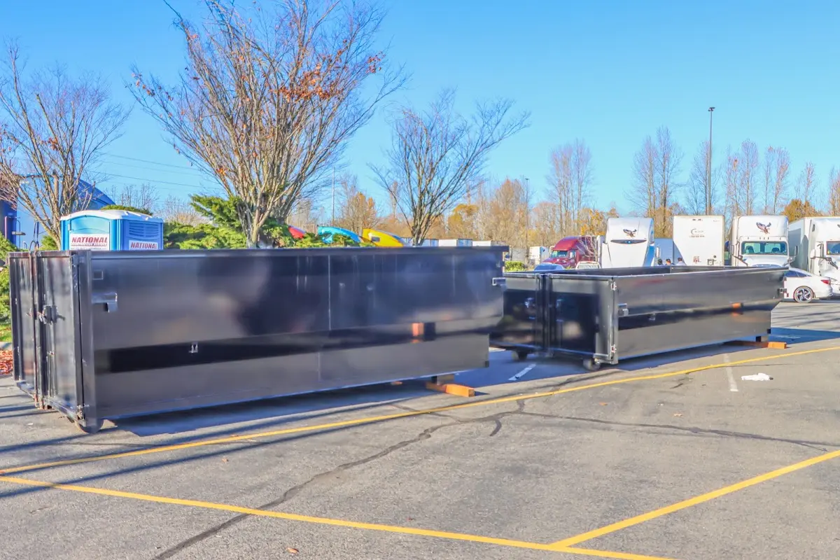 Professional dumpster rental service with roll-off container on residential driveway in Bay St. Louis